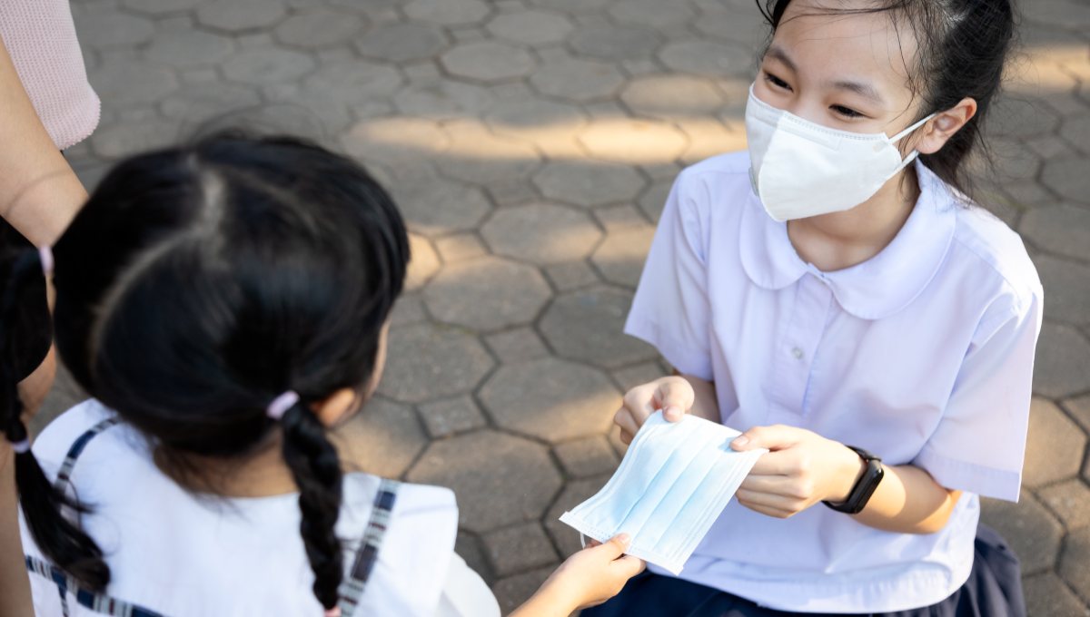 hai đứa trẻ san sẻ khẩu trang với nhau
